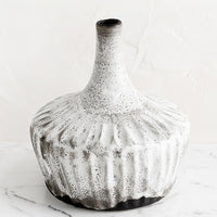 1: A ceramic vase in rustic white glaze over dark clay, with narrowed opening.