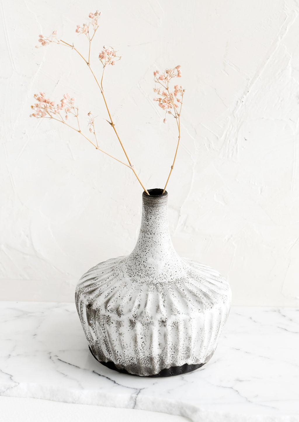 2: A ceramic vase in rustic white glaze over dark clay, with dried pink flower.