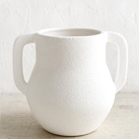 2: A textured matte vase in white ceramic with handles at sides.
