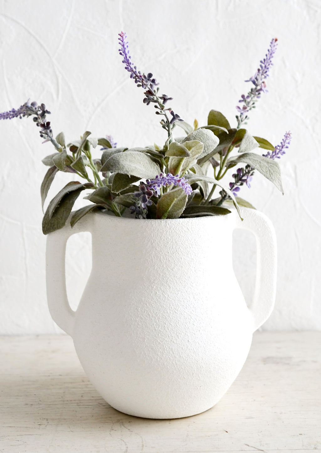 1: A matte white ceramic vase with lavender sprigs.