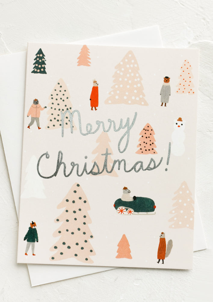 A greeting card with animals surrounded by pink Christmas trees and silver text reads "Merry Christmas!".