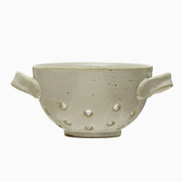 2: A small speckled ceramic berry colander with side handles.