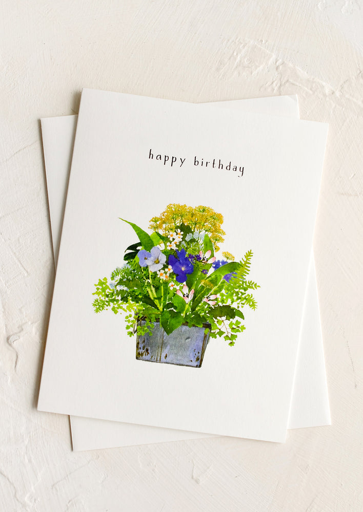 A birthday card with image of flowers in a planter and text at top reading "happy birthday"