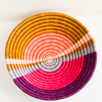 1: A round colorful woven sweetgrass basket with multicolor sunset design.