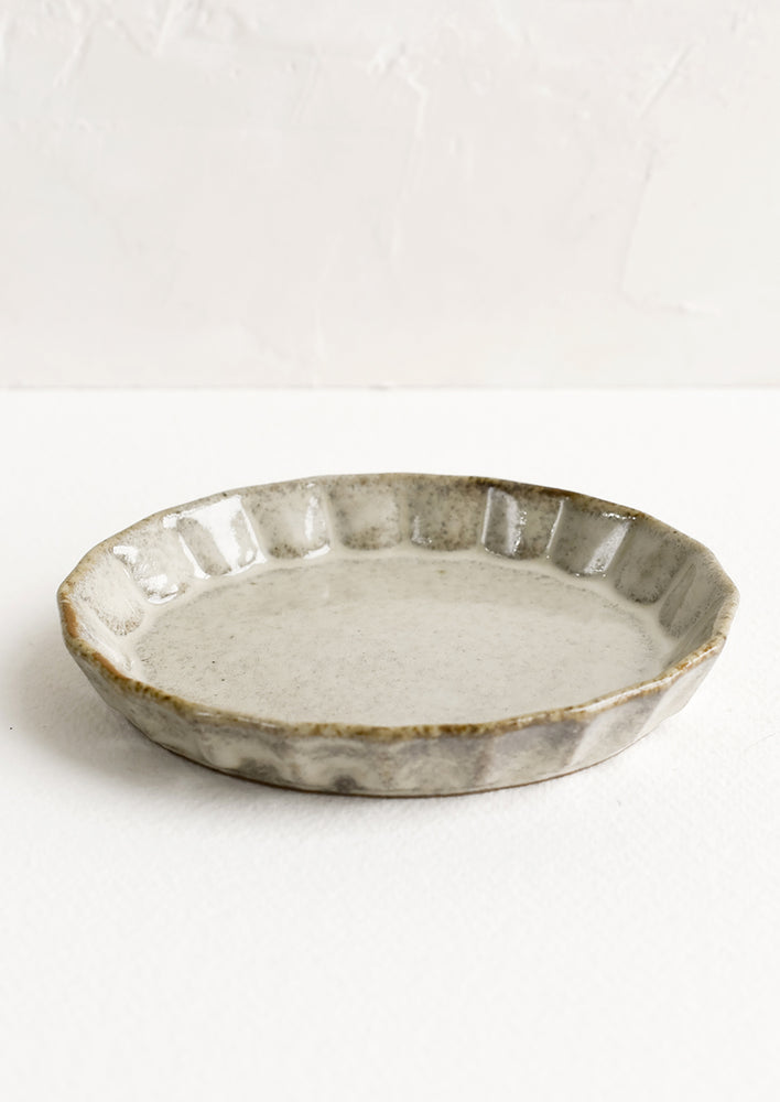 Natural / Oval: A small, oval shaped shallow dish with pleated edge in glossy natural clayglaze.
