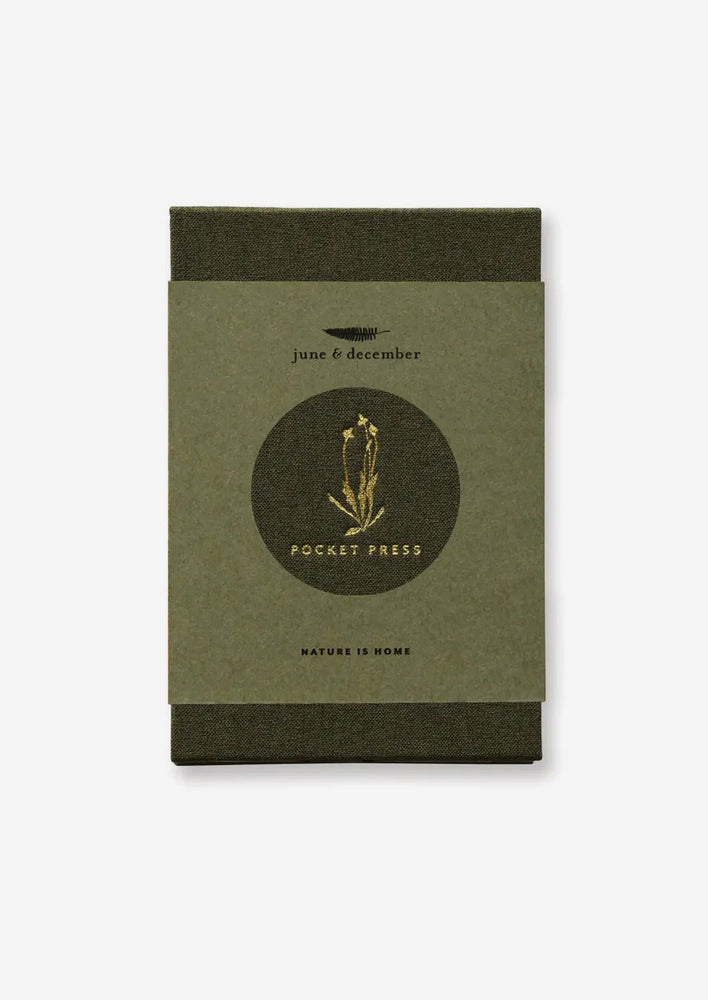 A green linen covered pocket-sized flower press booklet.