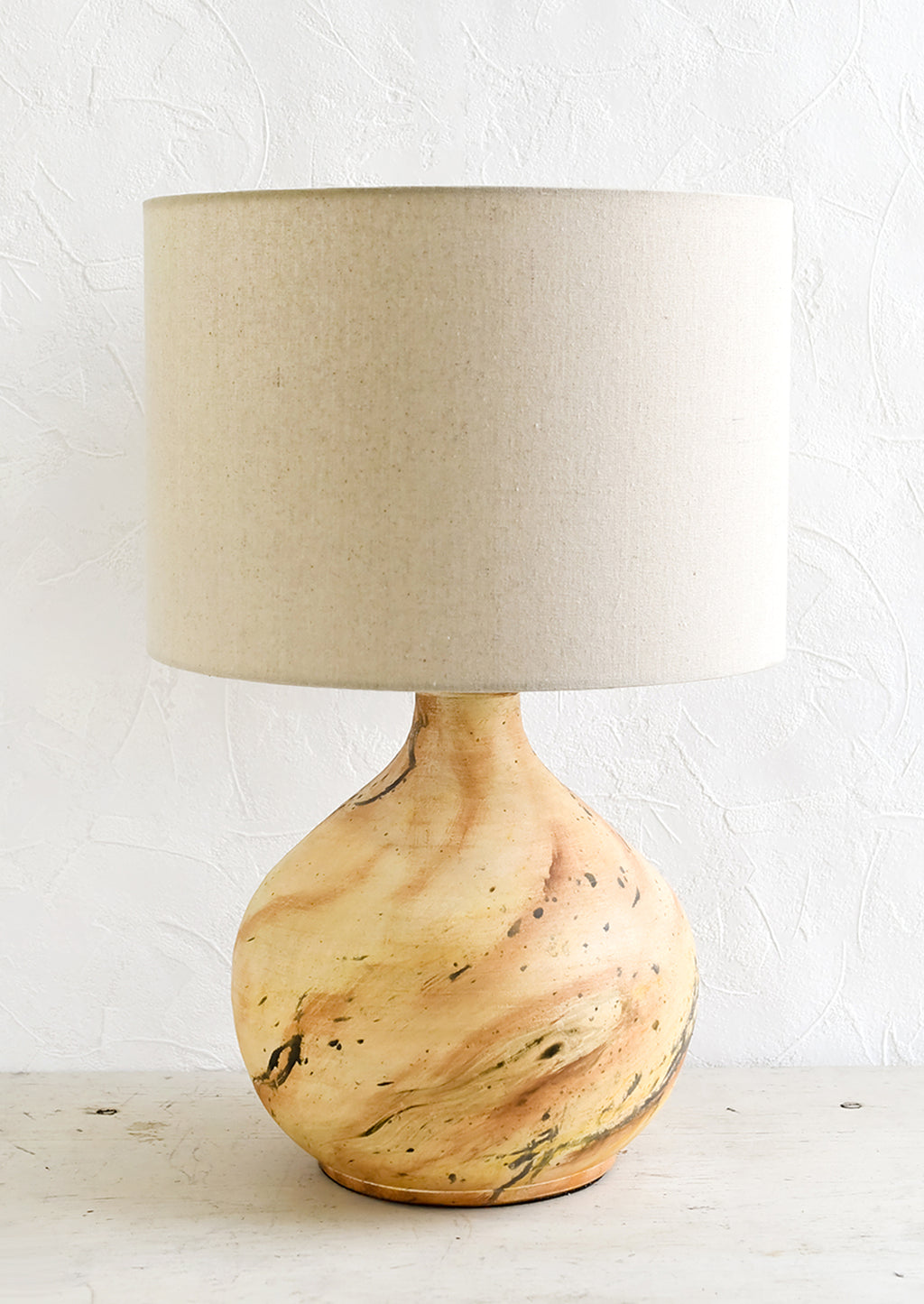 1: A table lamp with round ceramic base with paint splatter effect and round natural linen shade.
