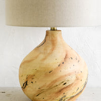 2: A table lamp with round ceramic base with paint splatter effect and round natural linen shade.