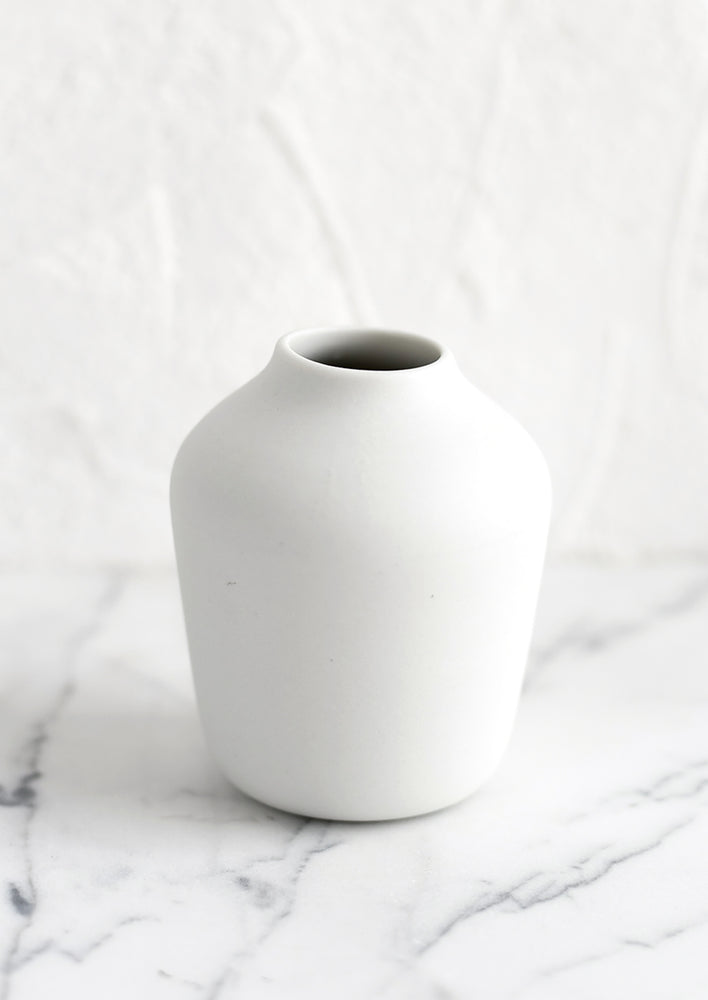 White: A white porcelain bud vase.
