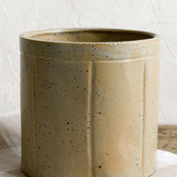 1: A round utensil crock in speckled tan ceramic with vertical line detail.