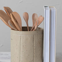 2: A round utensil crock in speckled tan ceramic with vertical line detail.