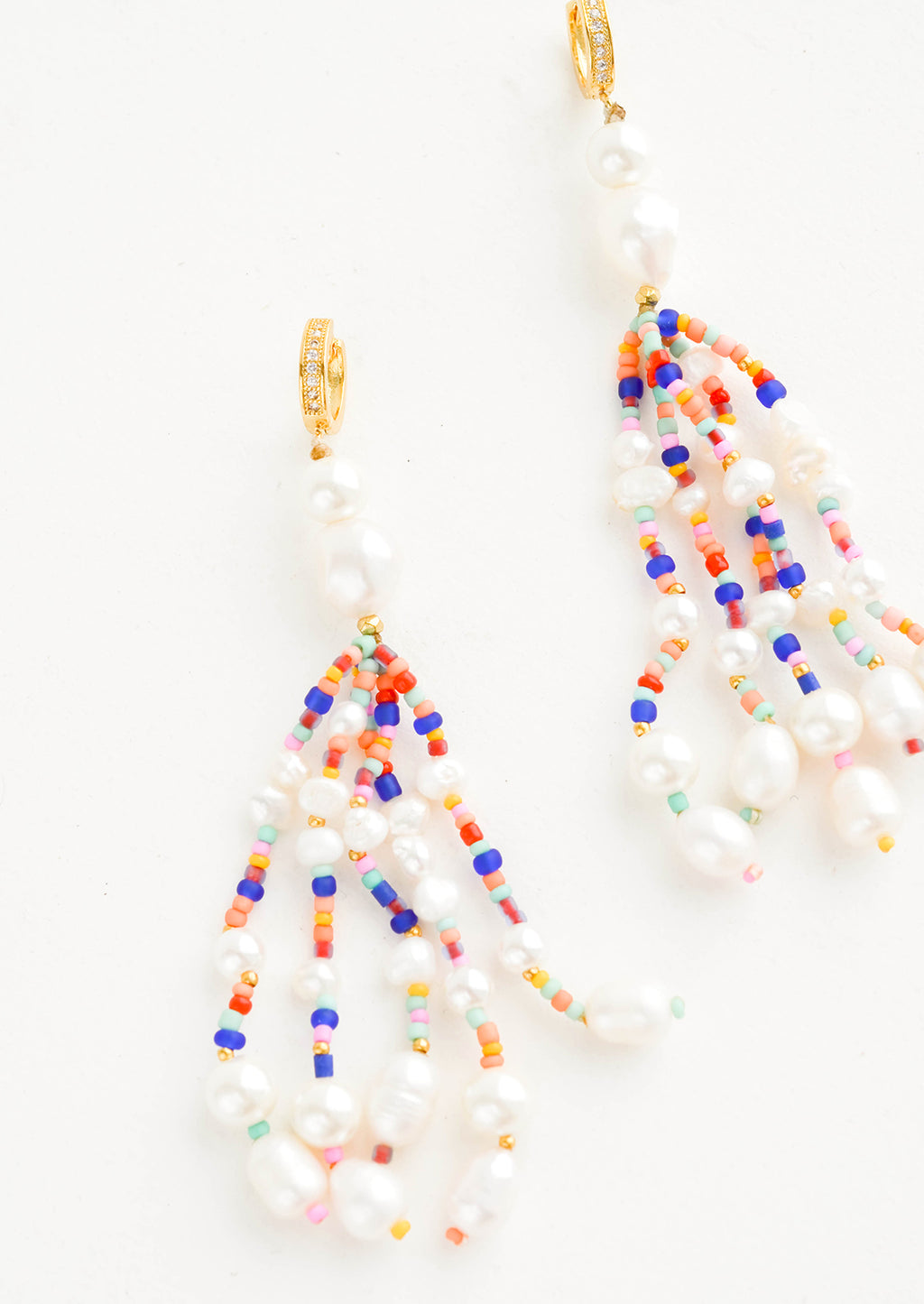 1: Earrings with multiple, heavily beaded dangling strands of large pearls mixed with small colorful beads