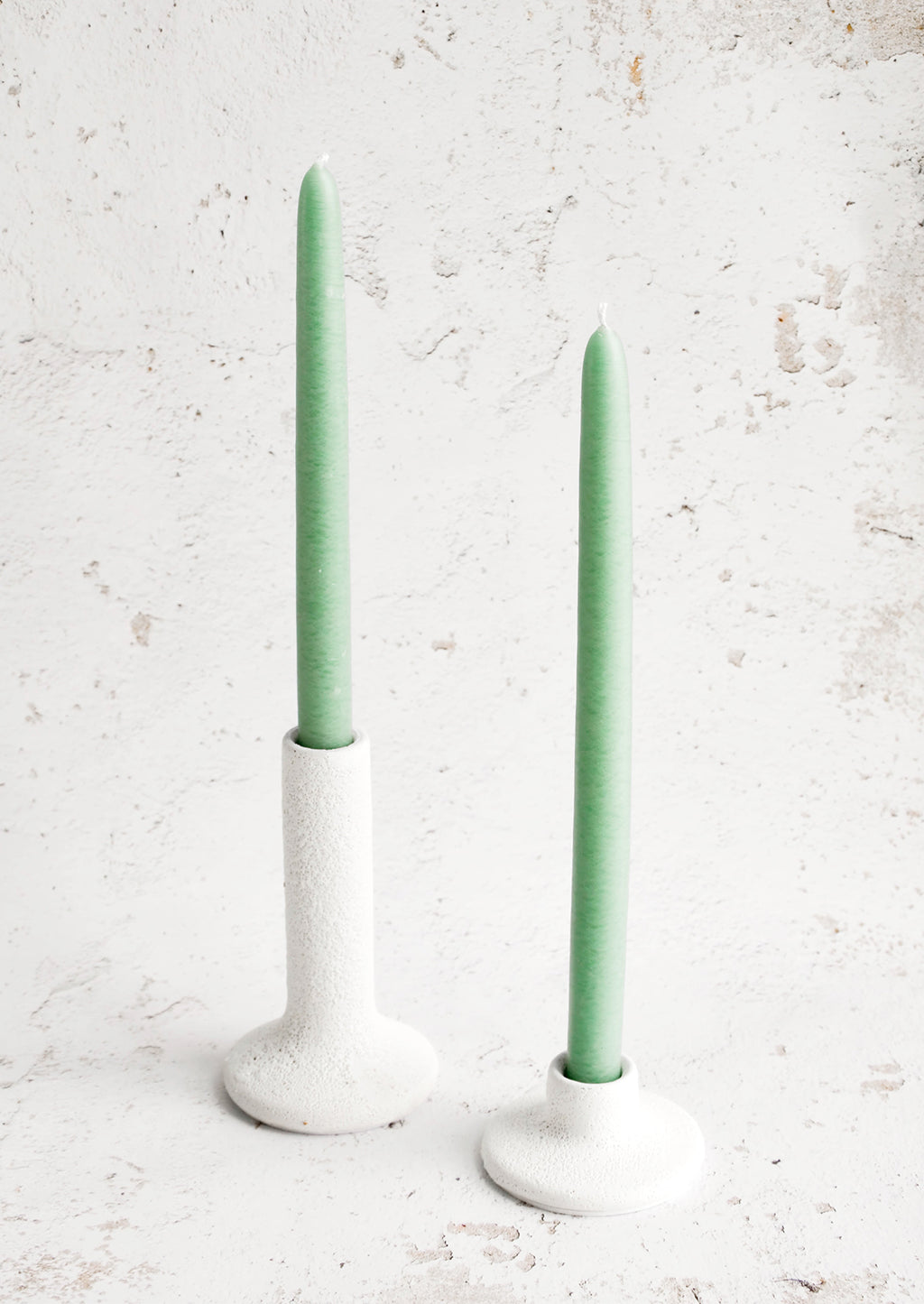 2: White ceramic taper candle holders in short and tall heights, displaying seafoam green taper candles