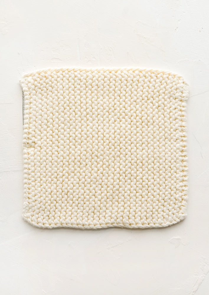 A square, chunky knit cotton potholder in off white.