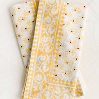 1: A pair of block printed napkins with yellow and red floral print.