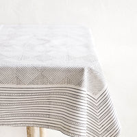 2: Black and white cotton tablecloth with geometric line and diamond print, displayed on a table