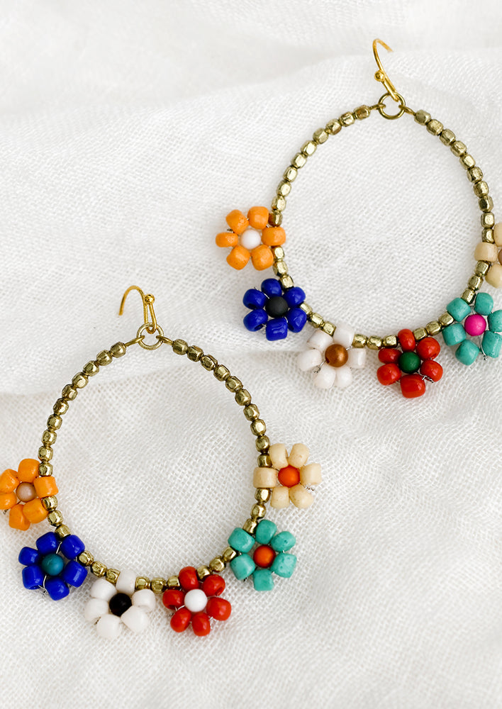 1: A pair of gold beaded hoops with multicolor flower beads.