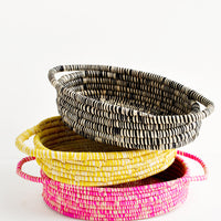 Black: Stack Of Oval Shaped Raffia Baskets in black, yellow, and pink.