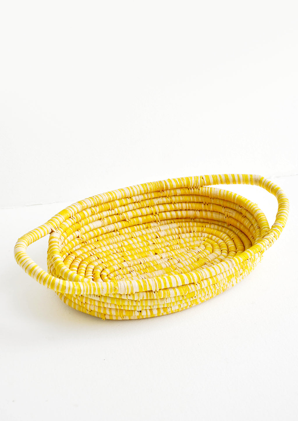 Yellow: Oval Shaped, Shallow Woven Raffia Basket with two side handles in yellow.