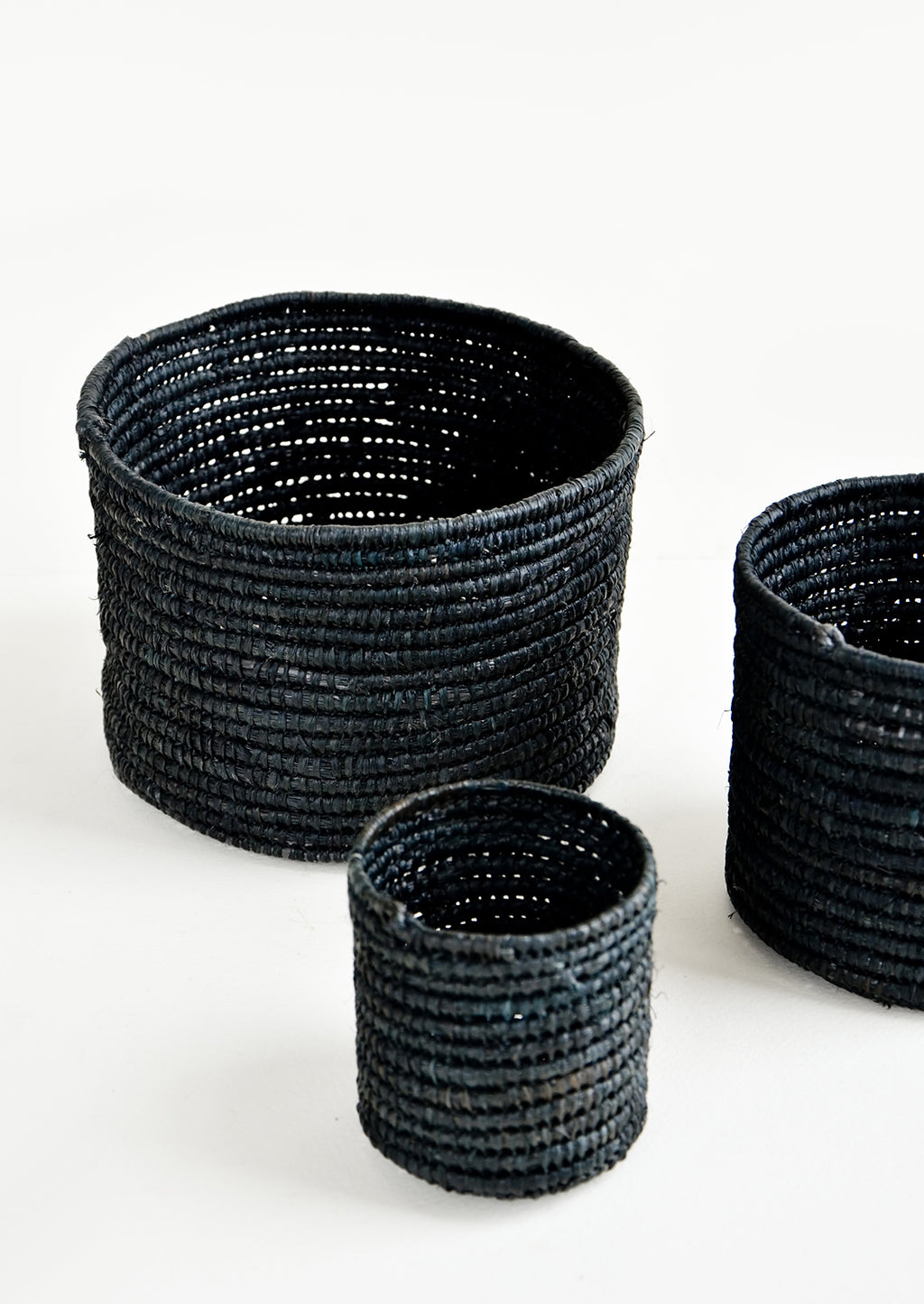 Extra Small / Black: Set of round catchall baskets made black raffia in three incremental sizes.