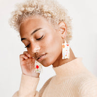 2: Model wears fringe earrings of cream and multicolored beads.