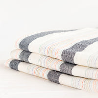 2: Stack of Cotton Turkish Towel in Natural & Charcoal with Rainbow Colored Stitching - LEIF