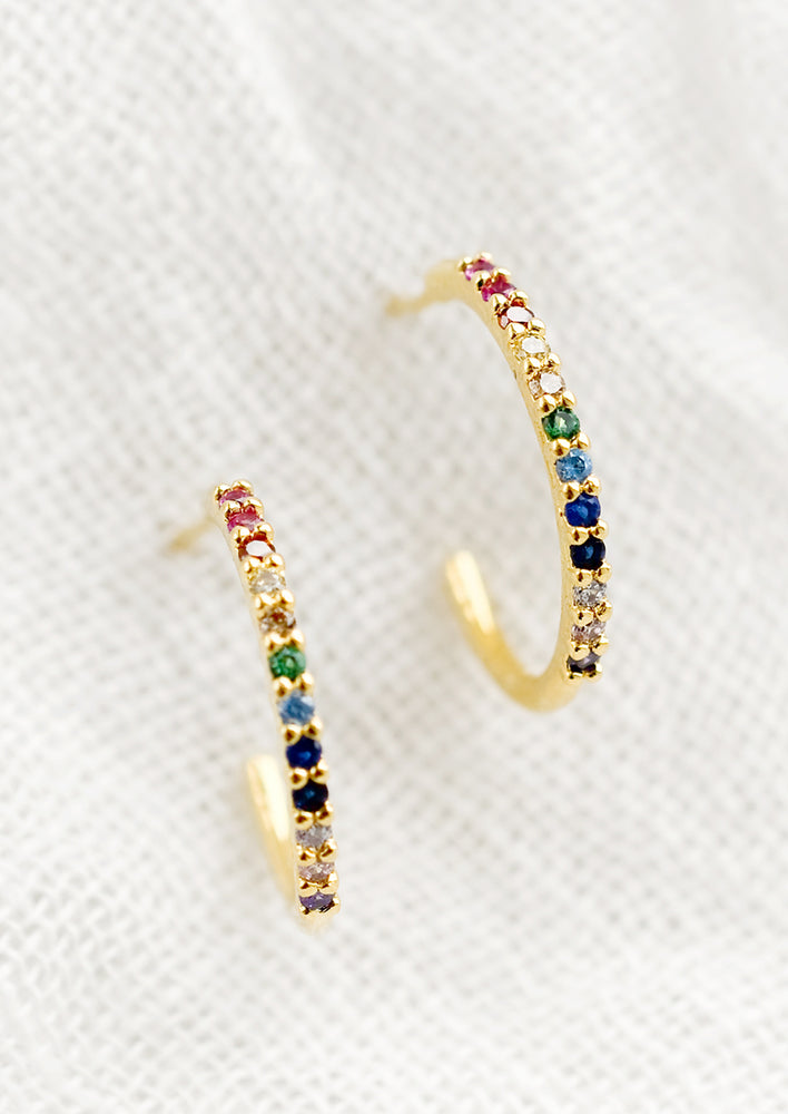 Small gold hoop earrings with rainbow color gradient.