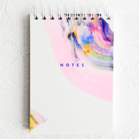 Notepad (Unruled): A small white spiral bound notepad with rainbow swirl painted cover and "NOTES" on front.
