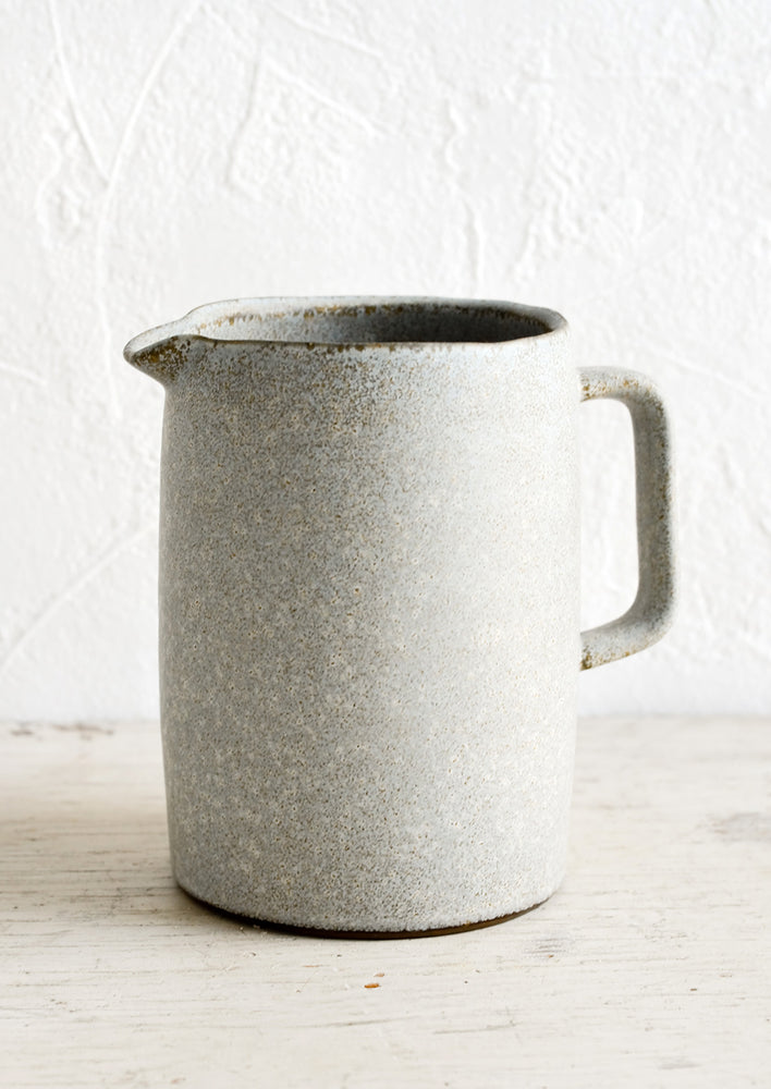A ceramic pitcher in rustic blue-grey glaze and modern, minimal silhouette.