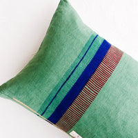 3: Back of linen throw pillow showing a series of block printed stripes and exposed brass zip closure