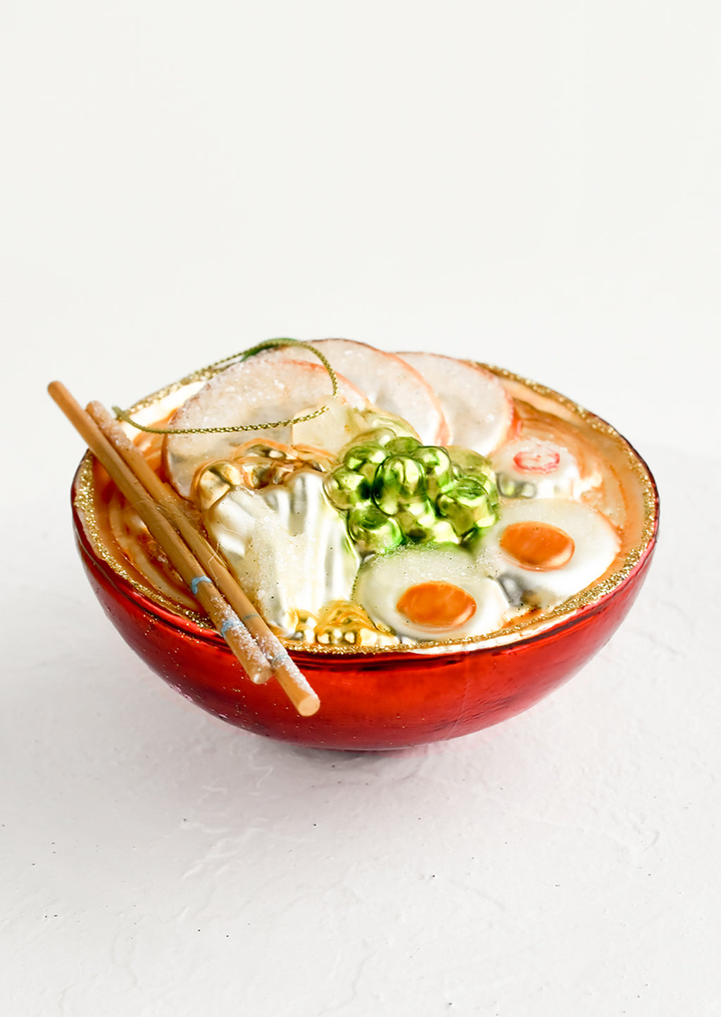 2: A decorative glass ornament in the shape of ramen noodle bowl.