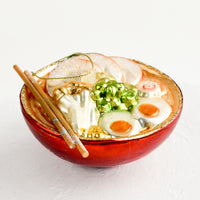 2: A decorative glass ornament in the shape of ramen noodle bowl.