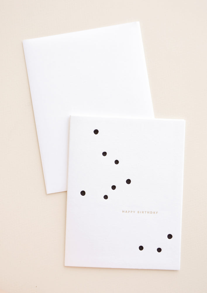 White greeting card with randomly scattered dots and small golden text reads "Happy Birthday"