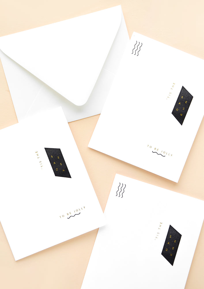 Three white greeting cards with minimal black and white geometric design and small gold text
