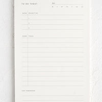1: A white notepad with guided prompts for listing daily tasks and priorities.