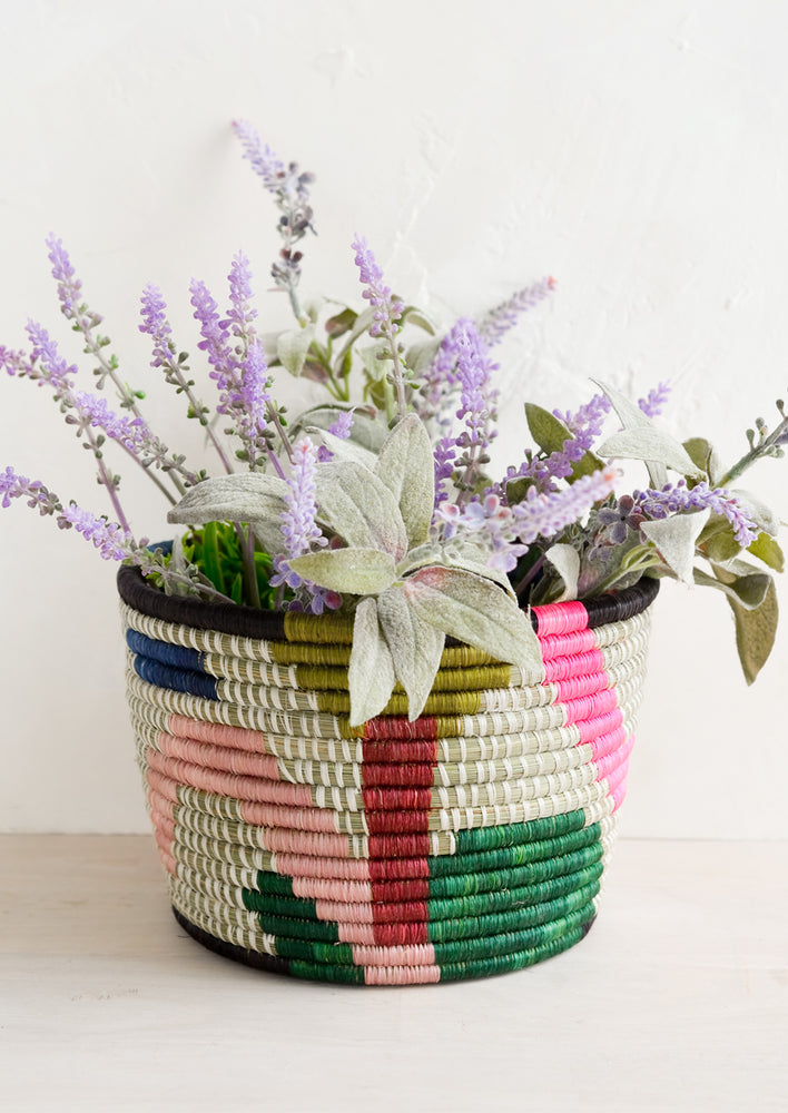 A colorful woven planter basket with lavender plant.