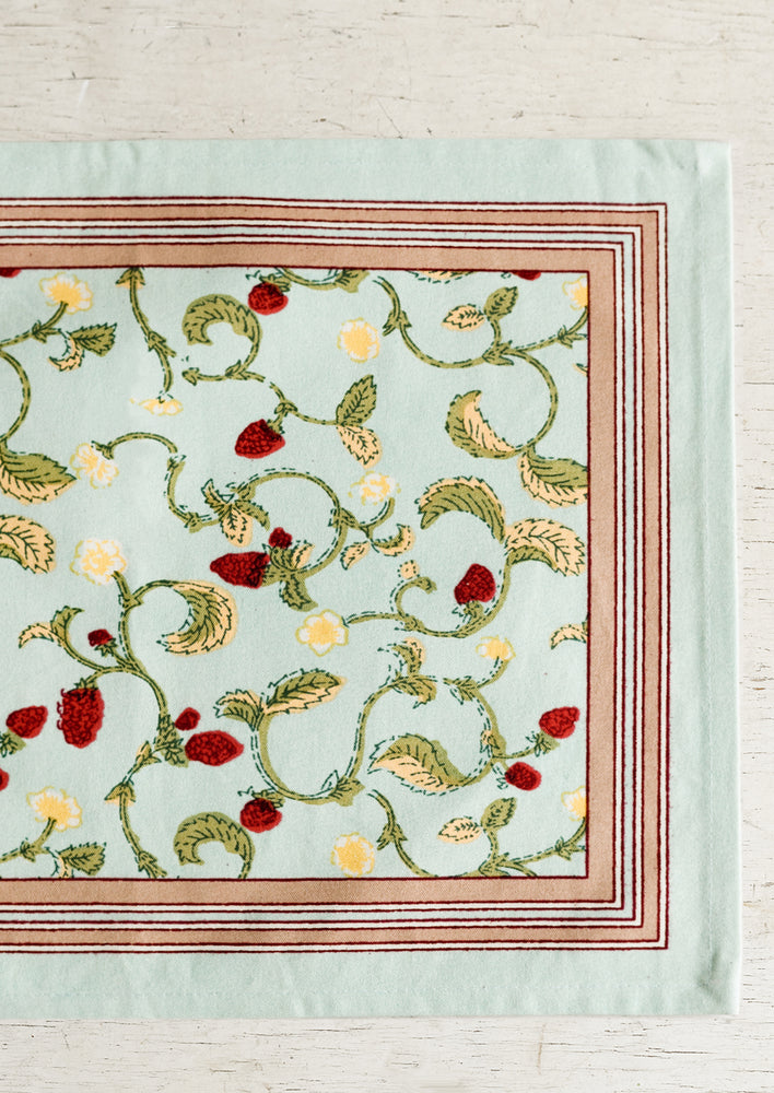 1: A light aqua placemat with bordered raspberry print.