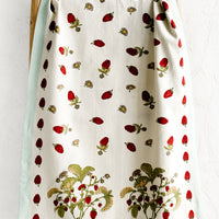 1: A cotton tea towel with wild raspberry print and aqua border.