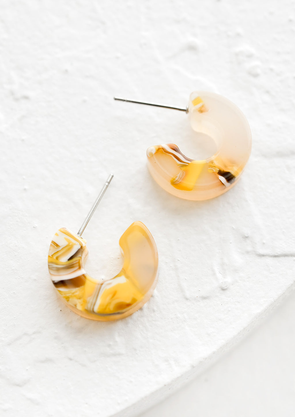 Sunflower Multi: A pair of small acetate hoop earrings in marbled yellow color.