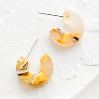 Sunflower Multi: A pair of small acetate hoop earrings in marbled yellow color.