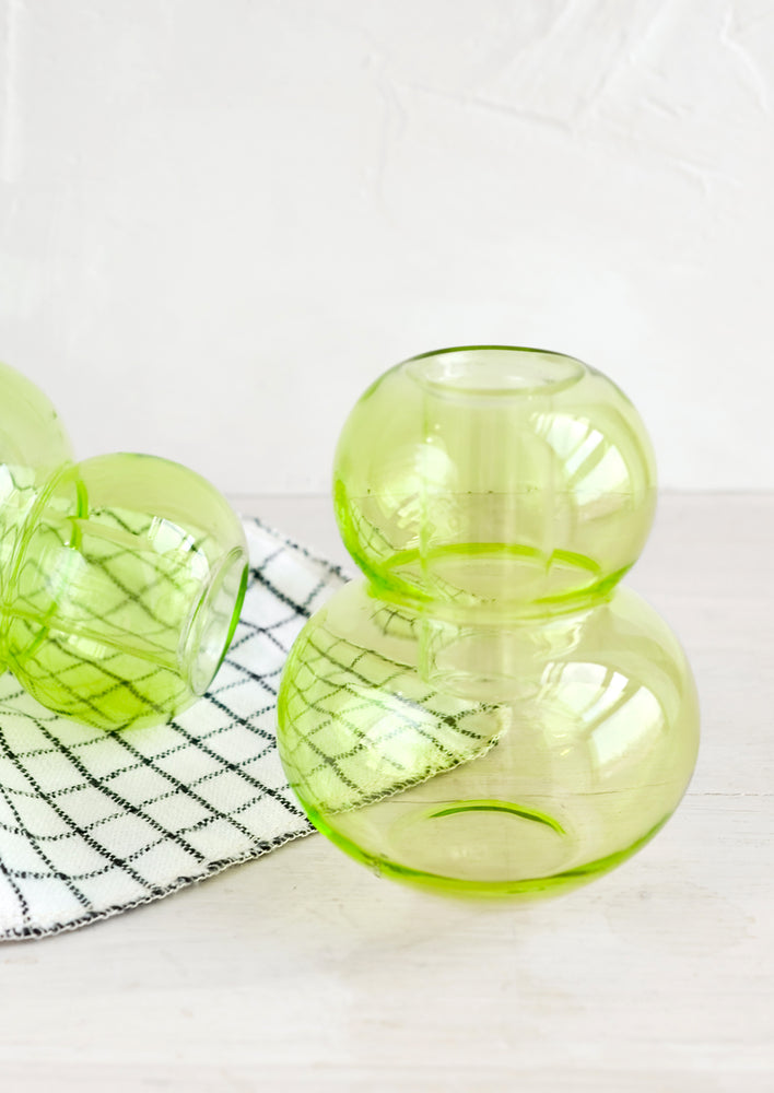 A bubble shaped glass taper candle holder in lime green.
