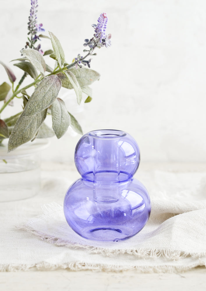 A bubble shaped glass taper candle holder in purple.