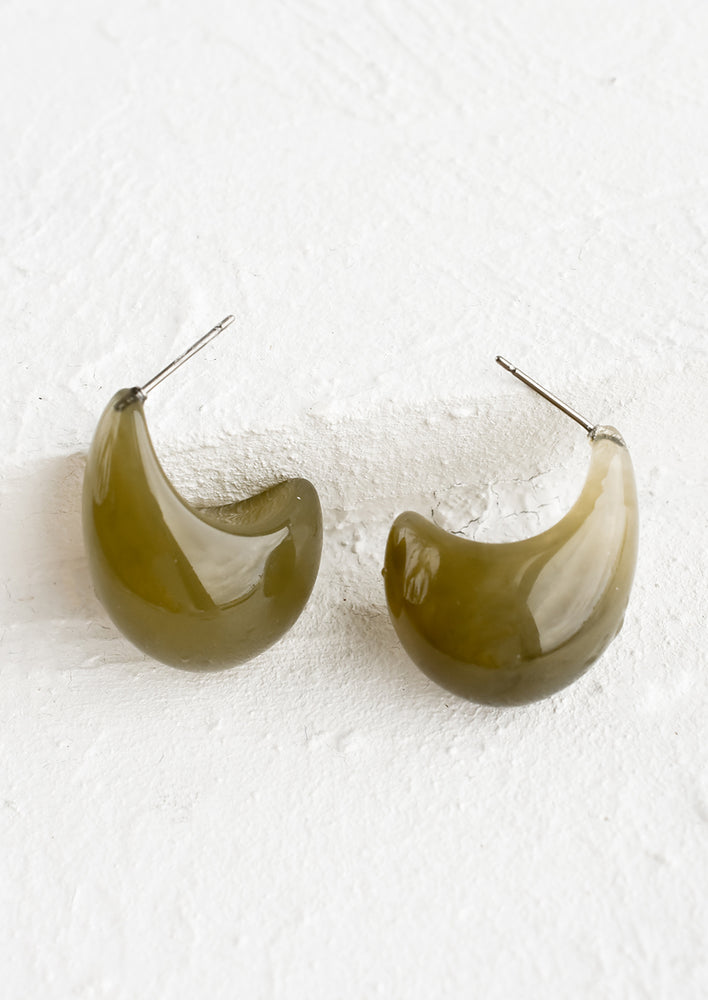 2: A pair of teardrop shaped resin earrings with curved bottom.