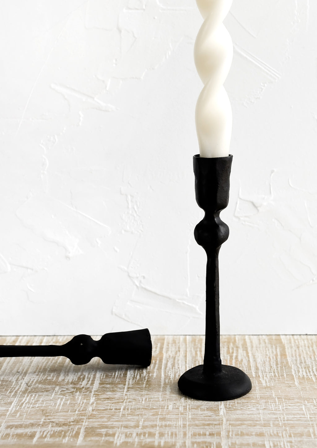 1: Black cast iron candle holders in spindly, carved silhouette.