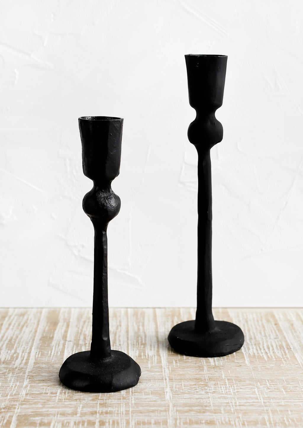 2: Black cast iron candle holders in spindly, carved silhouette.