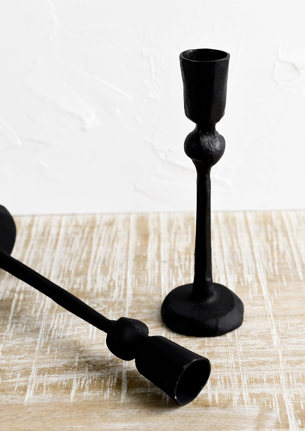3: Black cast iron candle holders in spindly, carved silhouette.