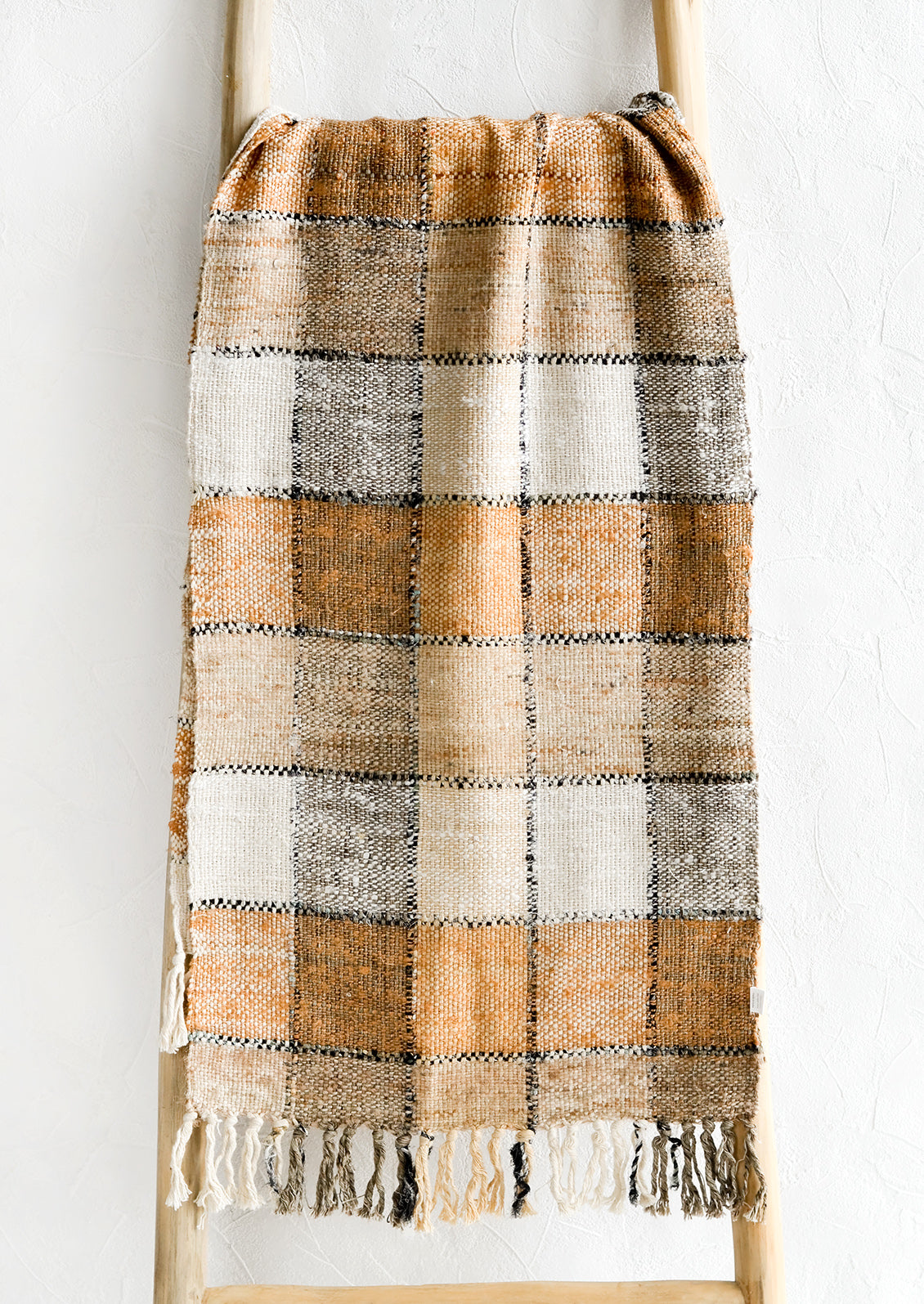 A table runner in shades of brown, black and white with checker pattern.