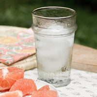 20 oz: A table setting with tall glass tumbler holding ice water.
