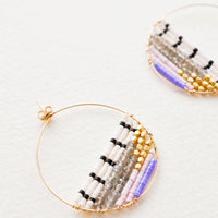 2: Close up of delicate gold hoop with multi-colored beads filling bottom half of hoop. 