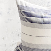 2: Square throw pillow in natural cotton with blue embroidery in striped patterns.